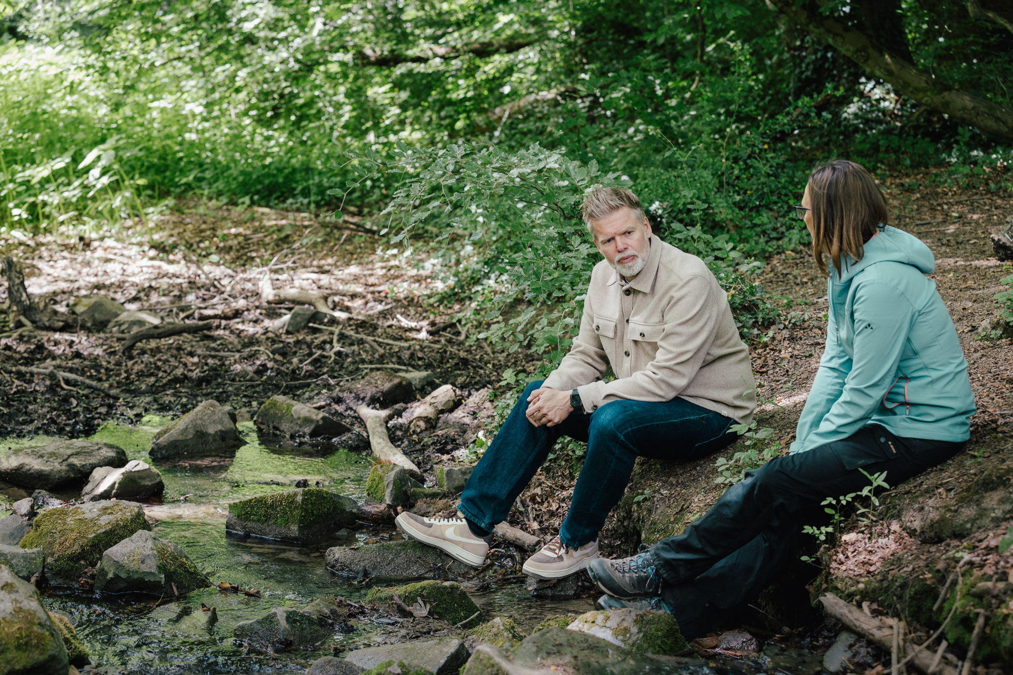Outdoor Coaching Gespräch am Bach im Wald